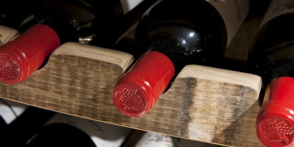 Nærbilde flasker i reoler eksklusive vinreoler